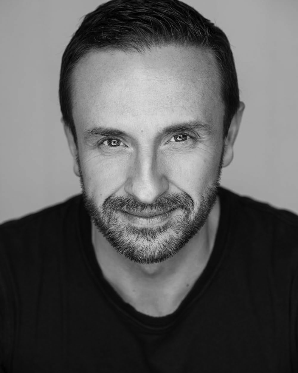 Black and white headshot of Sydney Theatre Company artistic director Mitchell Butel (white man with light beard in a black jumper).