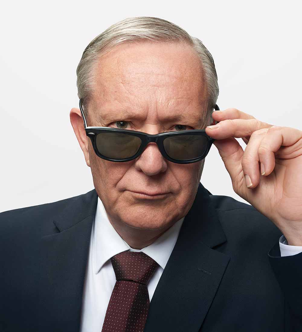Man wearing a suit and sunglasses.